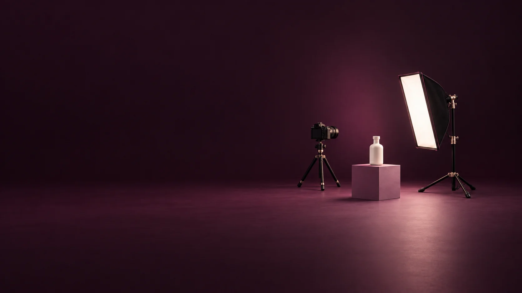 A camera on a tripod, an ivory bottle on a mauve plinth and a studio softbox.
