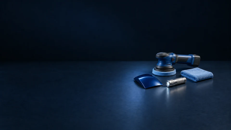 A compact cordless car polisher, folded blue microfiber cloth, inspection lamp and curved paint sample.