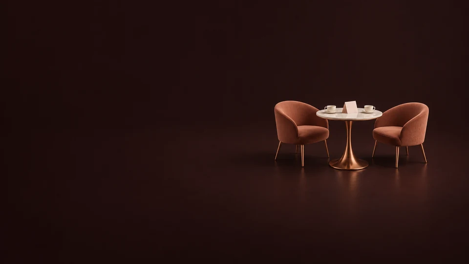 Two terracotta chairs around a copper cafe table with cups and a blank invitation.