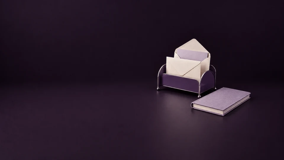 A violet mail rack holding blank envelopes beside a lavender notebook.