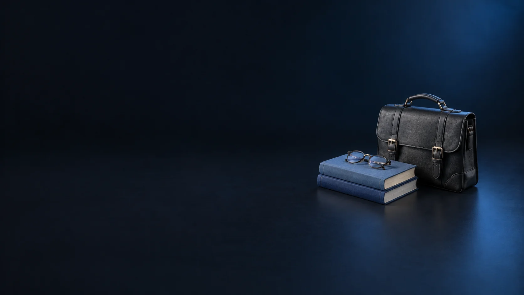 A dark leather study satchel beside two blue cloth books with folded reading glasses on top.