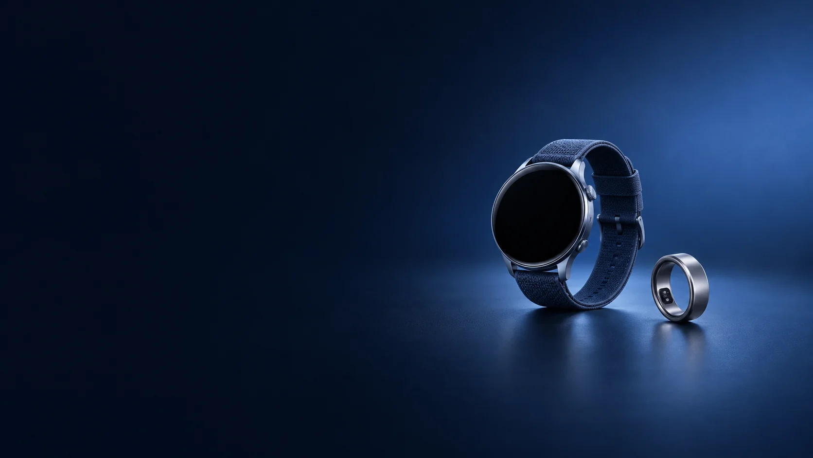 Round smart watch with a blue fabric band beside a titanium ring.