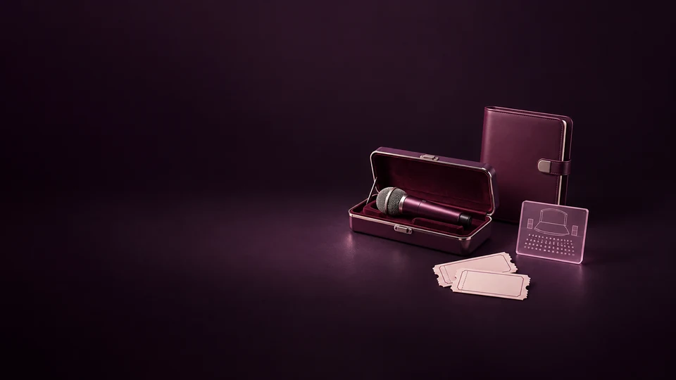 A microphone in its fitted case beside a blank booking folio, miniature stage-plan tile and two unmarked tickets.