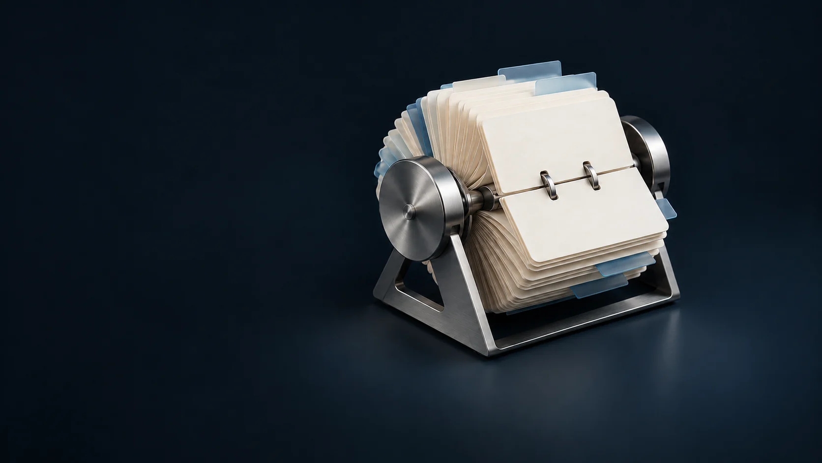 A brushed-aluminum rotary card index with blank ivory cards and blue dividers.