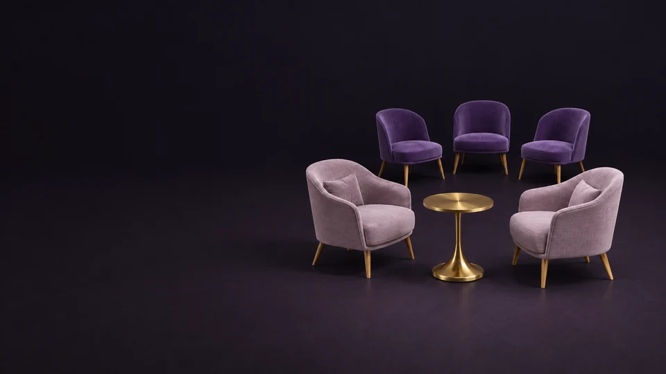 Two empty mauve reading chairs around a brass table, with three separate empty event chairs behind.