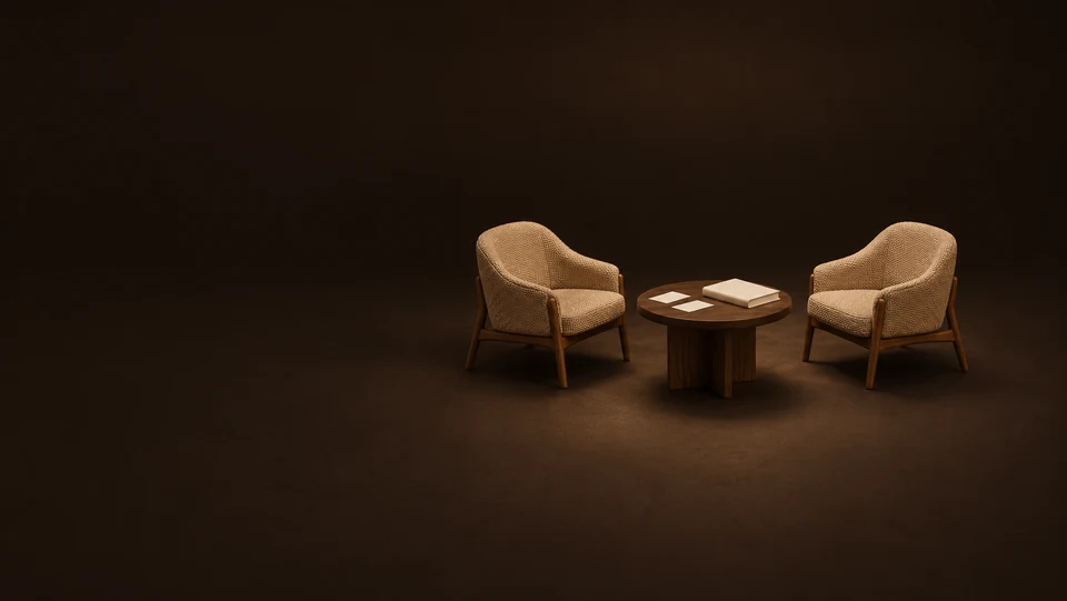 Two empty camel chairs around an oak table with paired blank cards and a closed workbook.