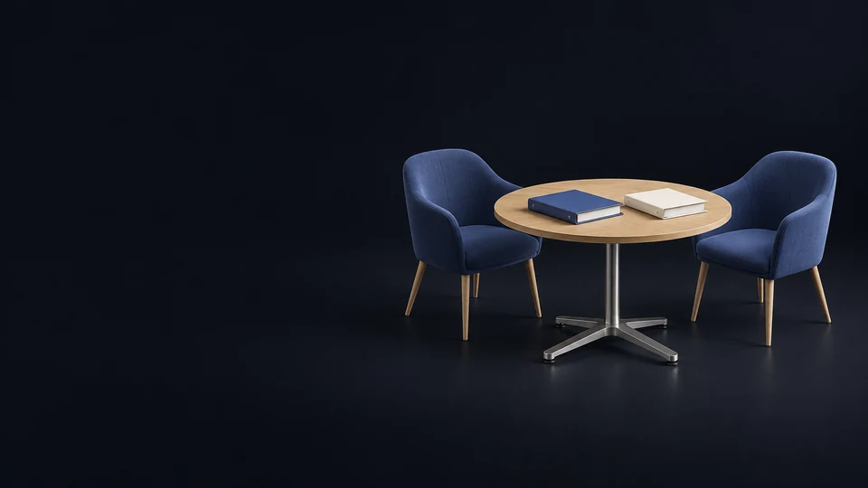 Two empty indigo chairs around a complete round oak seminar table with separate blank indigo and ivory binders.