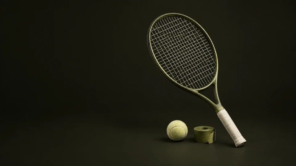 An olive tennis racket with cream grip stands beside a pale ball and an overgrip roll.